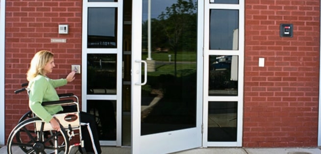 lady using handicap door opener at a swinging door