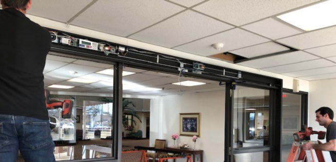 two technicians fixing the automatic door